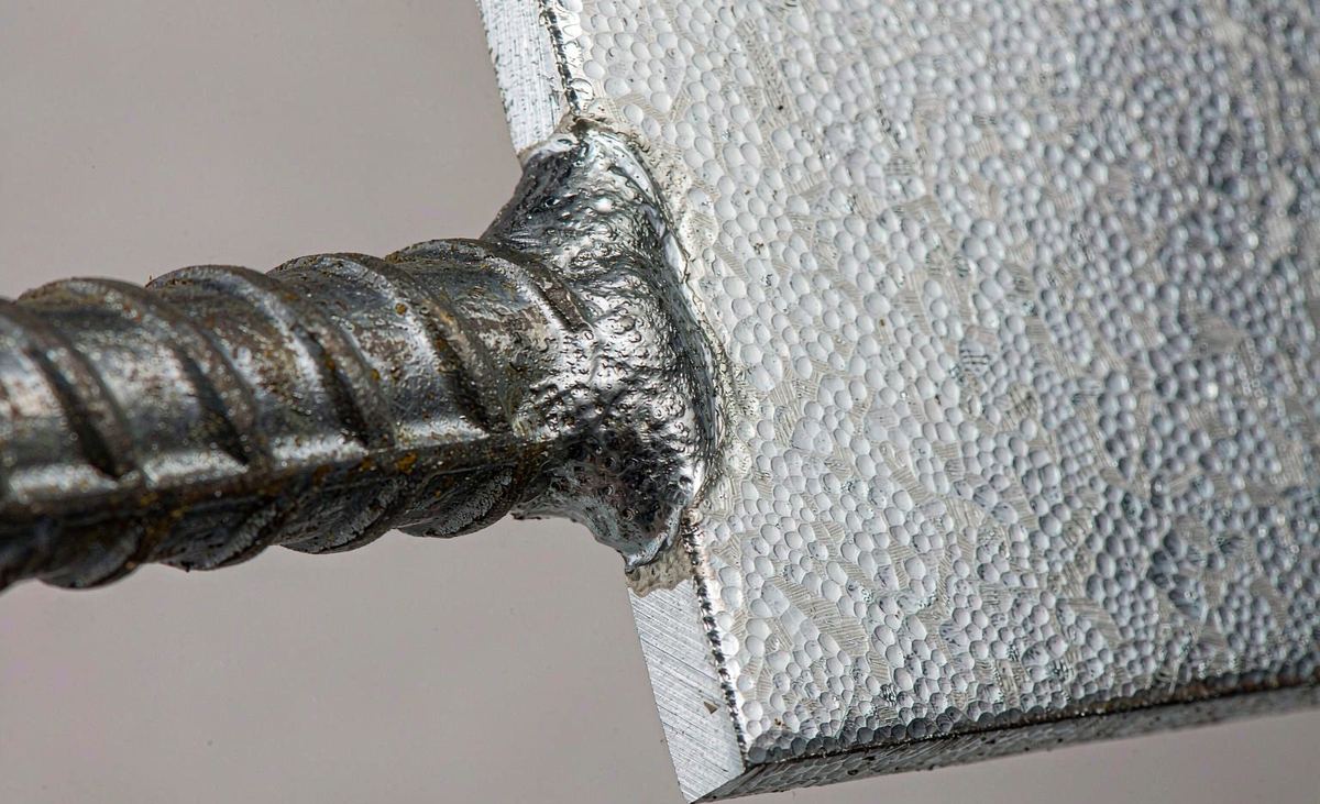 Close-up of fillet weld between deformed anchor bar and galvanized embedded steel plate