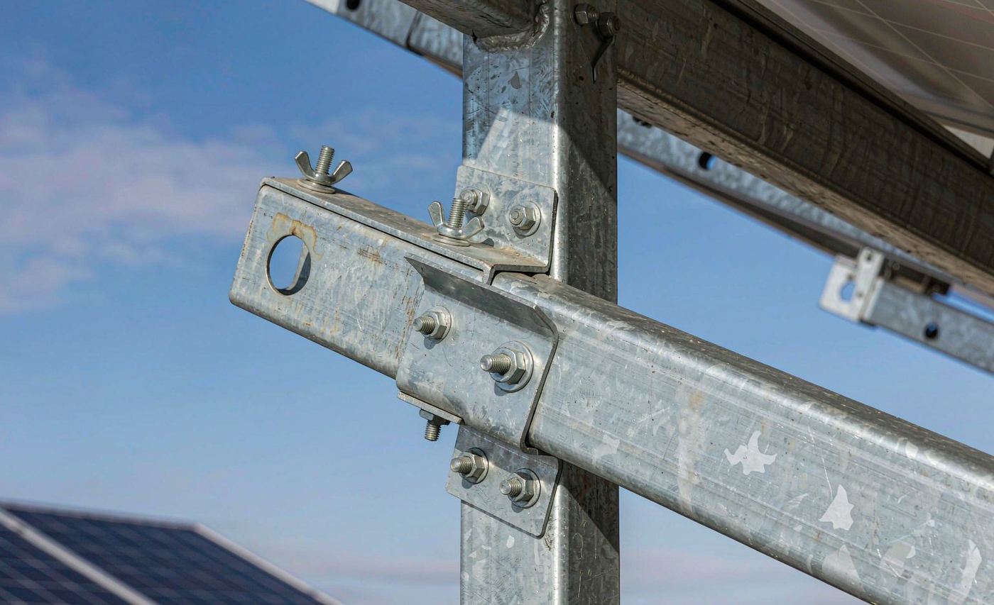 L-shape adjustable angle bracket connecting vertical post and horizontal rail on a solar mounting structure