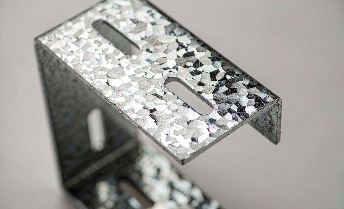 Close-up of slotted adjustment holes and crisp 90 degree bend on galvanized L bracket