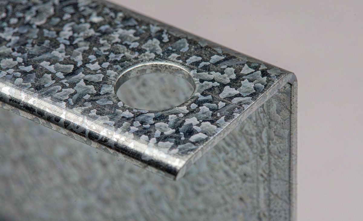 Close-up of stamped bend and punched adjustment hole on galvanized steel PV clamp